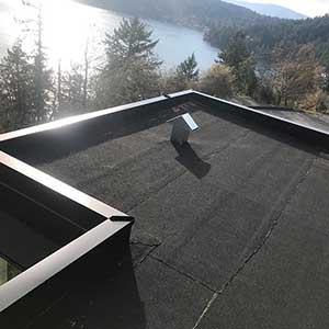 Top view of a flat, gray roof recently worked on by High Definition Roofing